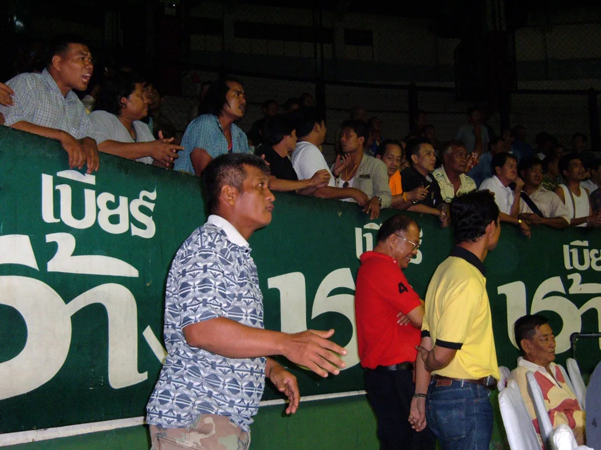 The crowd at ringside during a Muay Thai match at Rajadamnern Stadium